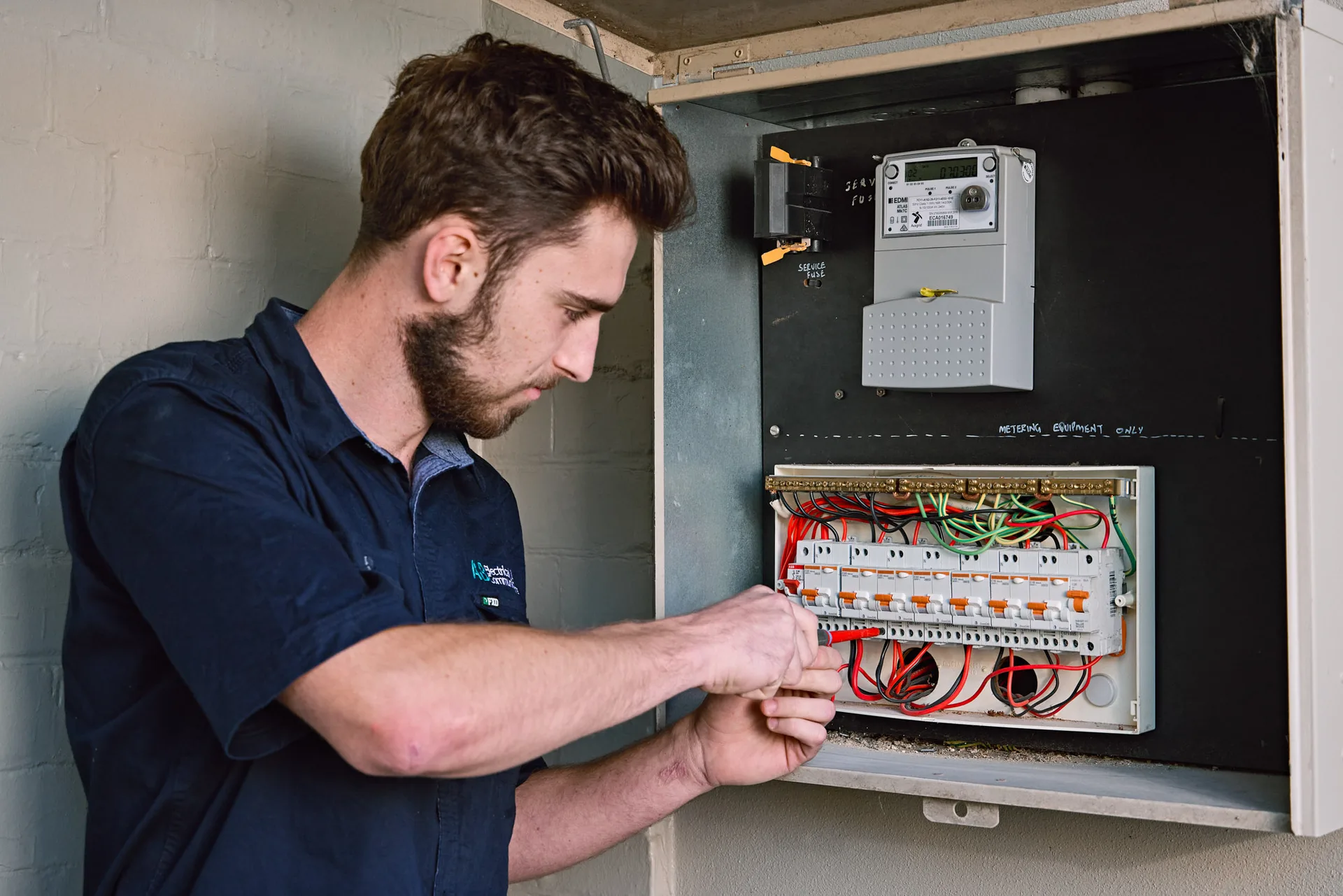Electrician working on the wiring inside a switchboard